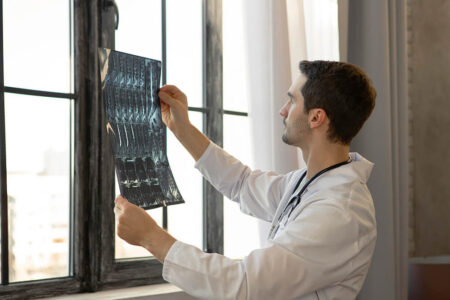 medico che guarda una radiografia eseguita da un macchinario per radiografie di ibis