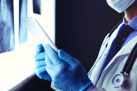 dottore che guarda le radiografie su un tablet in un ambulatorio medico